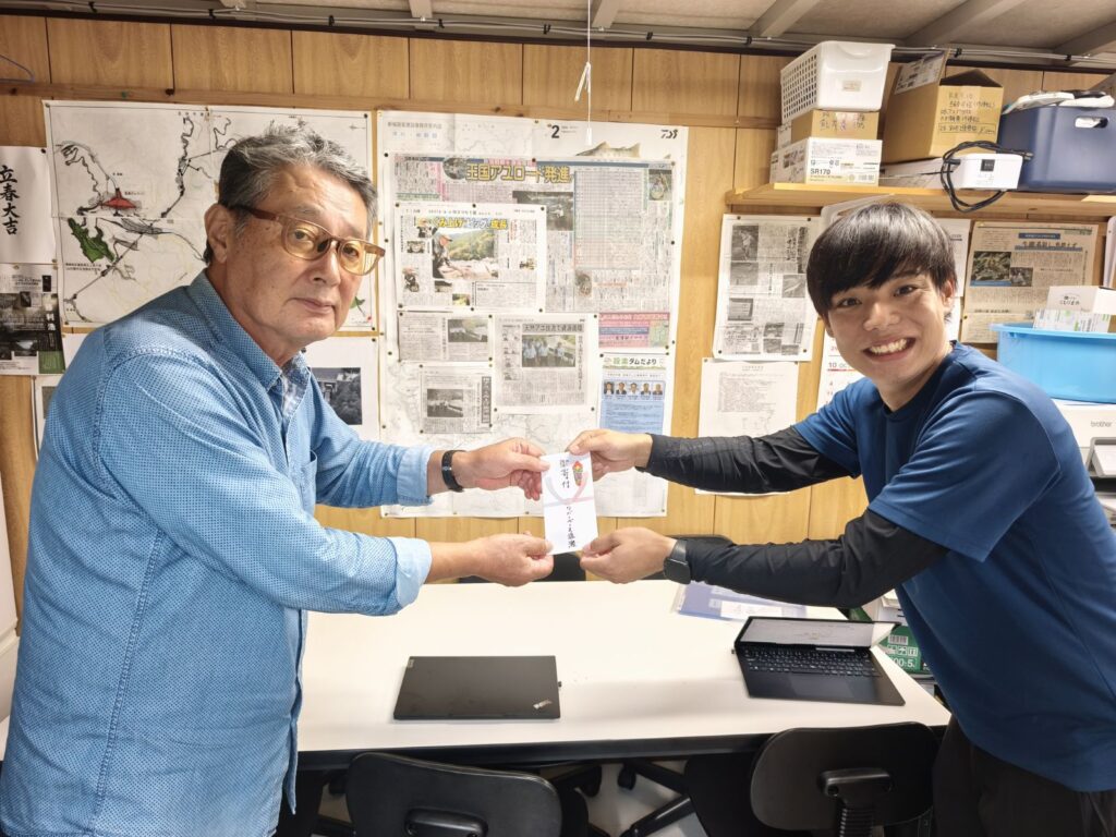 寒狭川中部漁協の組合長へ寄付をお渡しするリバーベース塩瀬の瀧本